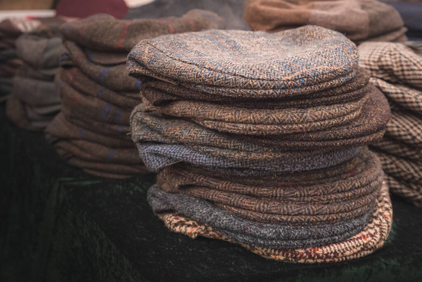 Gorras de tweed de punto de país inglés tradicional apiladas en exhibición para la venta. - Foto, imagen