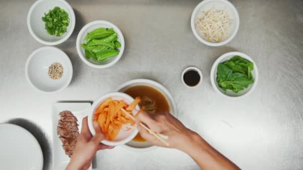 Felül kilátás a hagyományos ázsiai zöldség- és húsleves a semmiből. Felül lefelé néző hozzávalókat tálak a tésztaleves - Felvétel, videó