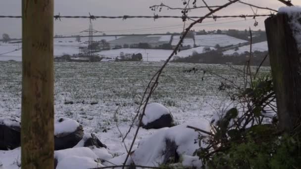 Rural snow scene through view of wooden fencing - Footage, Video
