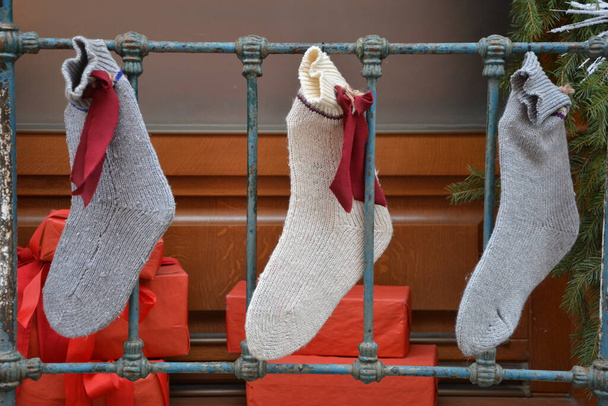 Счастливого рождественского приглашения. Повесить рождественские носки на серо-градиентном фоне. Красочное украшение чулок - Фото, изображение