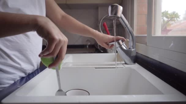 Osoba myjící nádobí v kuchyňském dřezu. Muž konající domácí práce. Nevypíná vodu z kohoutku a neplýtvá vodou, bez ohledu na životní prostředí. - Záběry, video