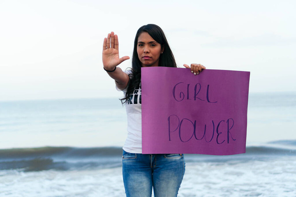 Portret van een vrouw die vecht voor haar rechten. Feminist die haar stem verheft en een teken vasthoudt dat protesteert voor rechten. - Foto, afbeelding