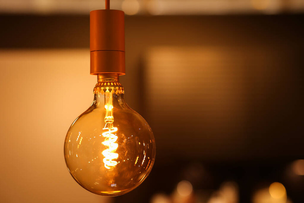 Žárovka nové generace. Teplé světlo v interiéru, dekorativní útulná lampa. - Fotografie, Obrázek