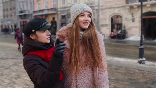 Due sorridenti donne sorelle turisti che camminano insieme sulla strada della città, coppia di famiglia che parla, abbracciando - Filmati, video