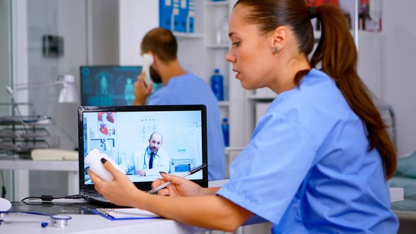 Rezident lékař mluvit s lékařem na videohovoru během virtuální schůze - Fotografie, Obrázek