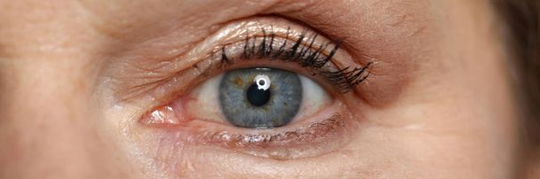 Μπλε μάτι ηλικιωμένης γυναίκας φαίνονται ευθεία. - Φωτογραφία, εικόνα