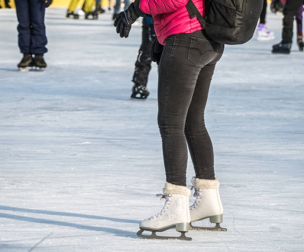 Attraente donna che pattina sul ghiaccio sulla pista di pattinaggio del parco Cismigiu, a Bucarest - Foto, immagini