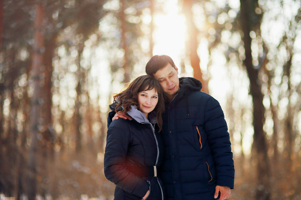 Зимний портрет молодой межрасовой пары, обнимающей друг друга - Фото, изображение