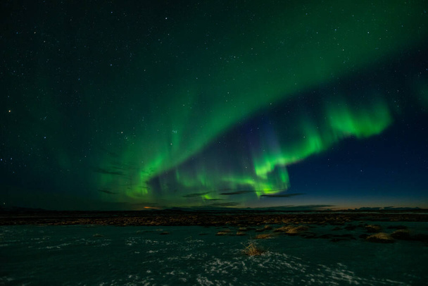 Kuzey ışıkları İzlanda 'da küçük bir kulübenin üzerine konuyor. - Fotoğraf, Görsel