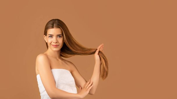 Millennial lady with pretty face and perfect skin showing long silky straight hair on brown background, banner design - Photo, Image