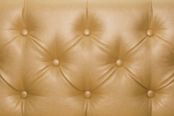 Žluté nebo zlaté kožené čalounění pohovka se vzorem tlačítko design nábytek styl dekorace textury pozadí. - Fotografie, Obrázek