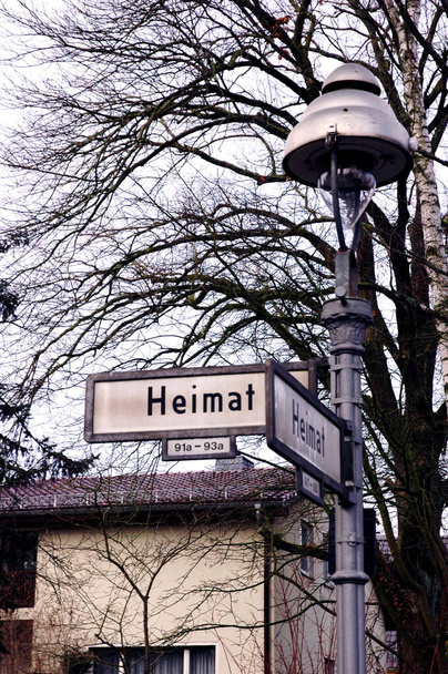 Nome de rua autêntico sinal HEIMAT (casa) com árvores, lanterna, casa suburbana na franja de Berlim - Foto, Imagem