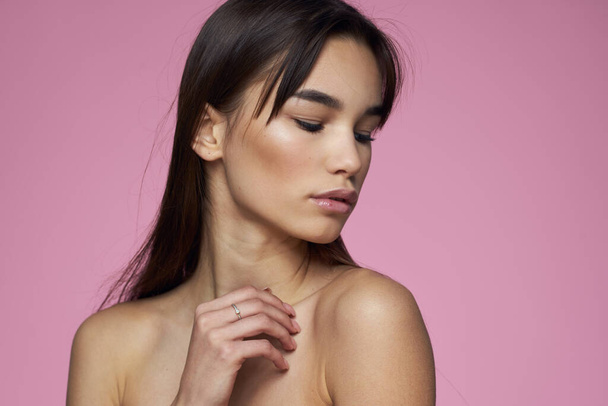 Woman with bare shoulders hair care makeup clean skin pink background - Φωτογραφία, εικόνα