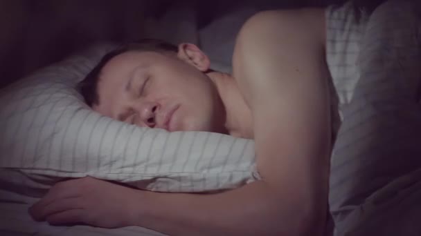 A young man goes to bed at night and immediately falls asleep - Footage, Video
