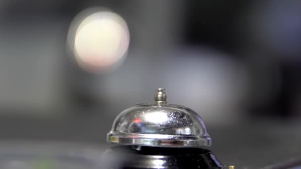 Campana de contador de plata sobre una superficie oscura con fondo borroso - Imágenes, Vídeo