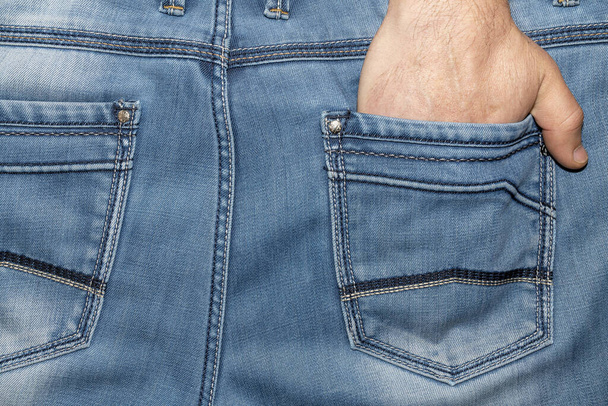 ένα αντρικό χέρι στην πίσω τσέπη του παντελονιού του - Φωτογραφία, εικόνα