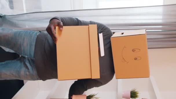 Вертикальный, неузнаваемый черный мужчина с картонной коробкой на голове, переезжающий в новую квартиру - Кадры, видео