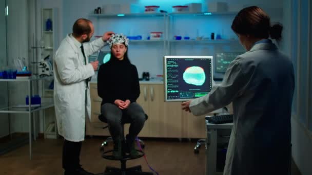 目のヘッドセットのセンサーを調べる男医師脳機能を監視する - 映像、動画