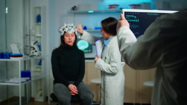 Αγχωμένος ασθενής κάθεται σε νευρολογική καρέκλα με eeg ακουστικά - Πλάνα, βίντεο