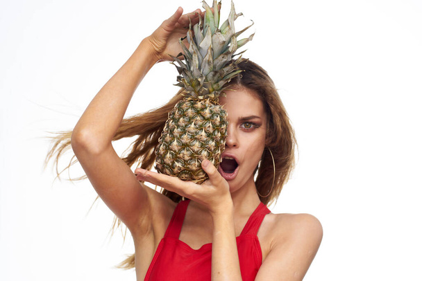Nainen ananas käsissä aaltoilevat hiukset punainen t-paita hedelmät kesäloma valo tausta - Valokuva, kuva