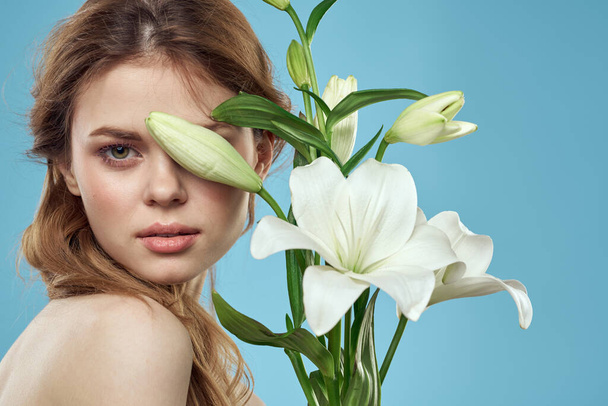 Dívka s kyticí bílých květin na modrém pozadí červené vlasy portrét model - Fotografie, Obrázek