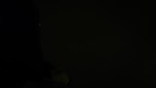 portrait of an asian man wearing a yellow mask in a dark room. the concept of a person during the Covid-19 pandemic taking care of his health. human footage with isolated black background - Footage, Video