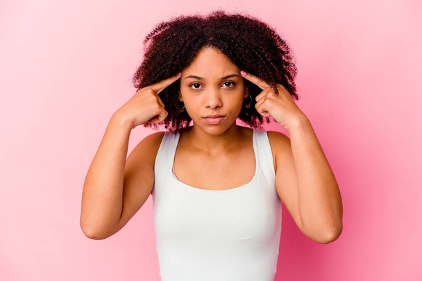 Giovane donna afro-americana mista isolato focalizzata su un compito, tenendo gli indici puntando la testa. - Foto, immagini