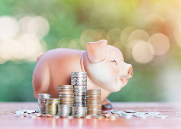 Piggy Bank y pila de monedas, concepto de ahorro de inversión en fondo fuera de foco. - Foto, imagen