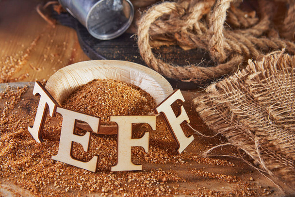 Teff, az ősi gluténmentes gabona alternatívája, fából készült betűkkel írva. Teff népszerű választás lett az egészséges táplálkozáshoz. - Fotó, kép