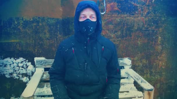 Homme avec masque protecteur assis sur lors de fortes chutes de neige - Séquence, vidéo