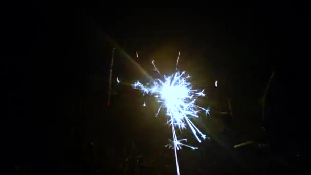 Πυροτέχνημα, βεγγαλικά και φώτα bokeh σε σκούρο μπλε φόντο - Πλάνα, βίντεο
