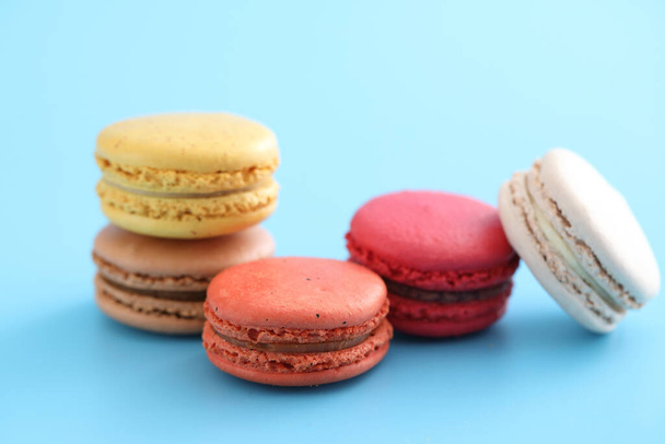 Colorful macarons isolated in blue background - Photo, Image