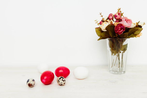 vacanza di luce Pasqua e uova dipinte sul tavolo un mazzo di fiori in un vaso - Foto, immagini