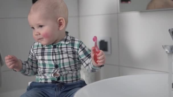 Le petit enfant se brosse les dents dans la salle de bain de la maison - Séquence, vidéo