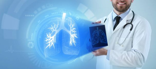Mies lääkäri tilalla tabletti tietokone ja virtuaalinen näyttö kuva keuhkot värillinen tausta - Valokuva, kuva