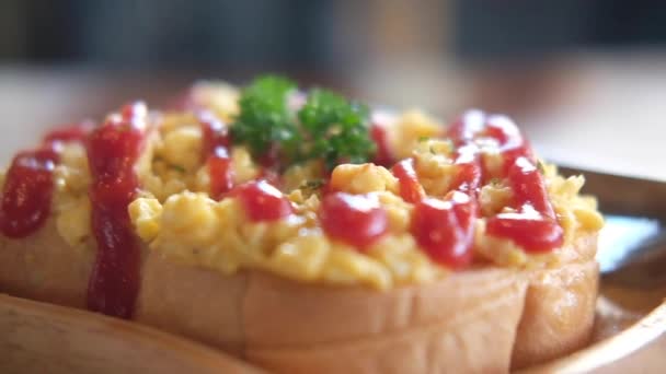 Close up scrambled eggs on toasted bread with ketchup, breakfast in morning at home. Panning shot - Footage, Video
