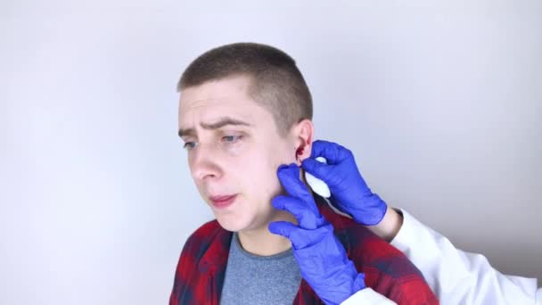 Un hombre cuyo oído está sangrando. Ruptura vascular, daño a la membrana timpánica, enfermedades del oído, oncología, otitis media, miringitis - Metraje, vídeo