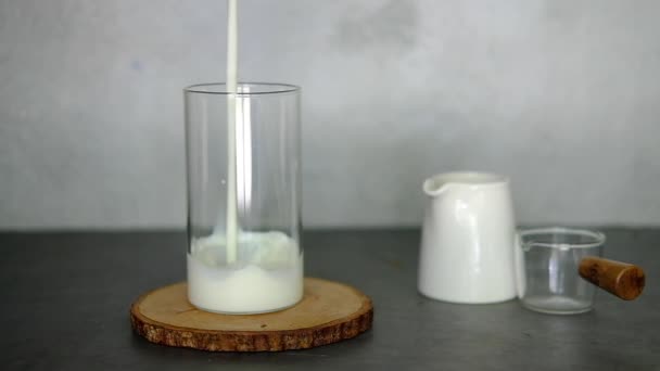 Close-up de leite é derramado em um copo. câmara lenta - Filmagem, Vídeo