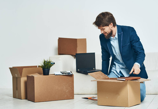 Ein Mann sitzt Kisten mit Dingen, die einen neuen beruflichen Job auspacken - Foto, Bild