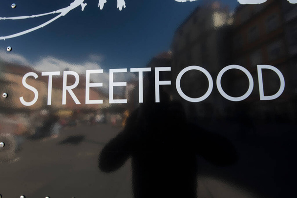Street Food υπογράψει σε ένα φορτηγό τροφίμων δρόμο, αντανακλώντας μαύρο φόντο - Φωτογραφία, εικόνα
