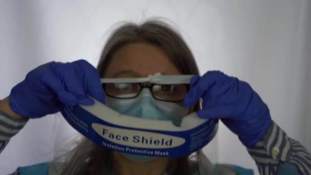 透明フェイスマスクの上に置く女性医療スタッフパイプ - 映像、動画