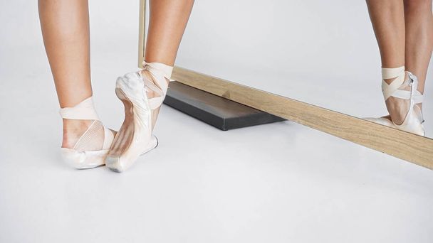 vista parziale della ballerina in scarpe da punta che balla vicino allo specchio - Foto, immagini
