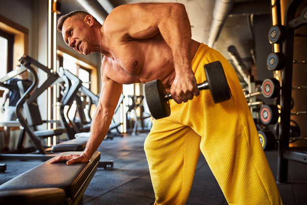 Hard-working male athlete doing physical exercises at gym - Photo, Image