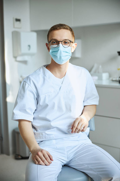 Healthcare worker in eyeglasses seated at his office - Photo, Image