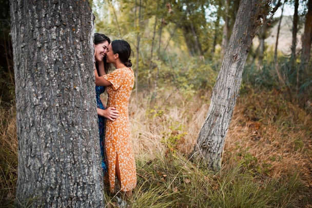 Dvě mladé lesbičky líbání a hlazení se v lese - Fotografie, Obrázek