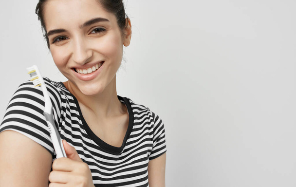 mujer alegre en camiseta a rayas higiene cepillo de dientes - Foto, imagen