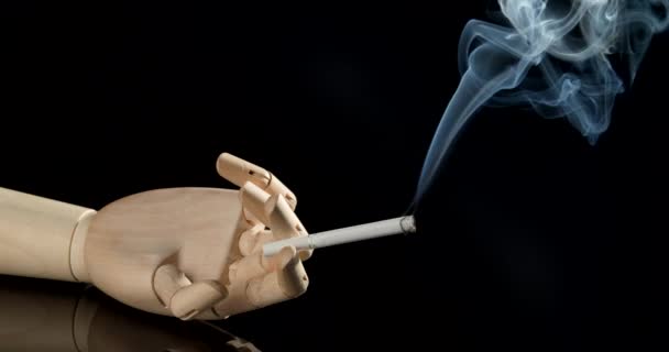 Dřevěná ruka s cigaretou na tmavém pozadí - Záběry, video