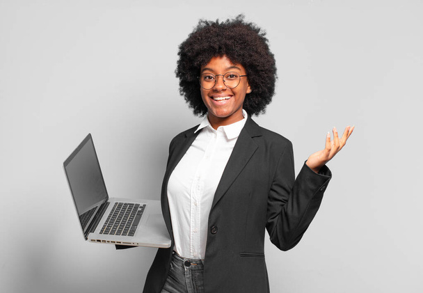 молодая афро-предпринимательница чувствует себя счастливой, удивленной и веселой, улыбаясь с позитивным настроем, реализуя решение или идею. бизнес концепция - Фото, изображение
