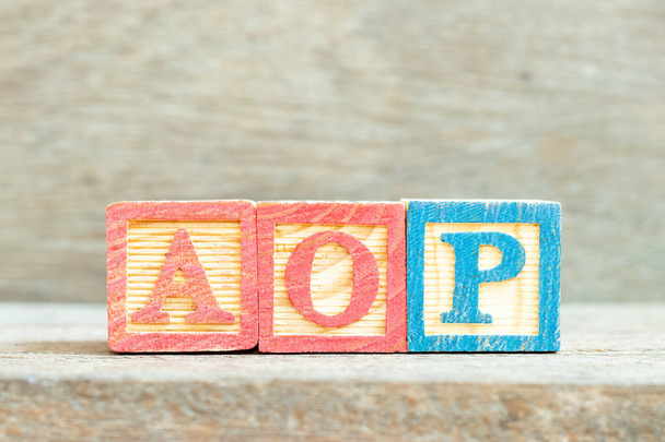 Színes ábécé betűblokk a szó AOP (rövidítése éves működési terv vagy Aspect-orientált programozás) a fa háttér - Fotó, kép