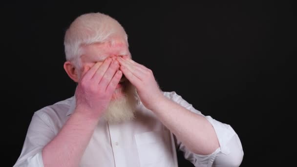 Człowiek z albinizmem podnosi rękę, by chronić oczy przed jasnym światłem.. - Materiał filmowy, wideo